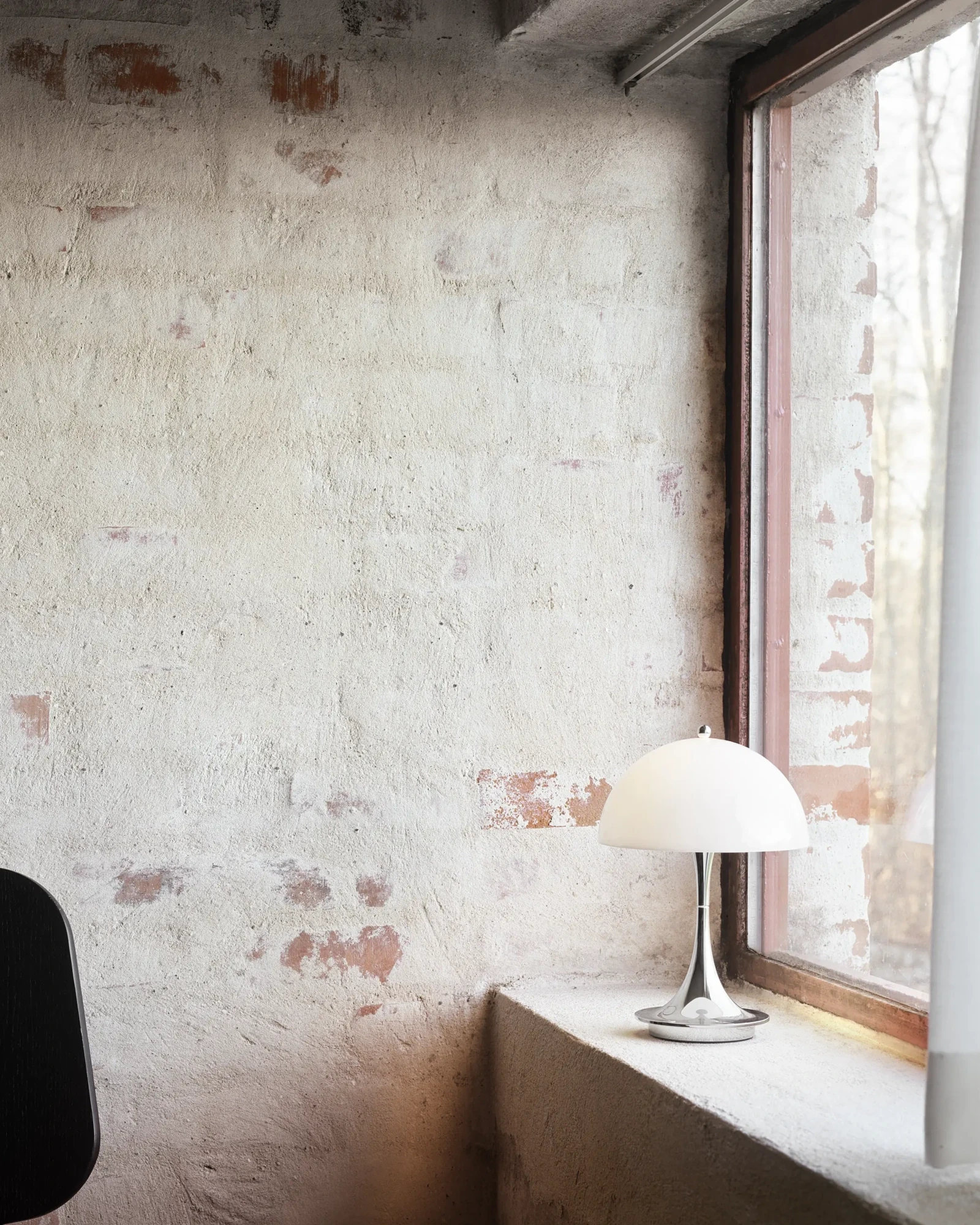 Louis Poulsen Panthella 250 Portable lamp glowing at dusk on a wooden pier.